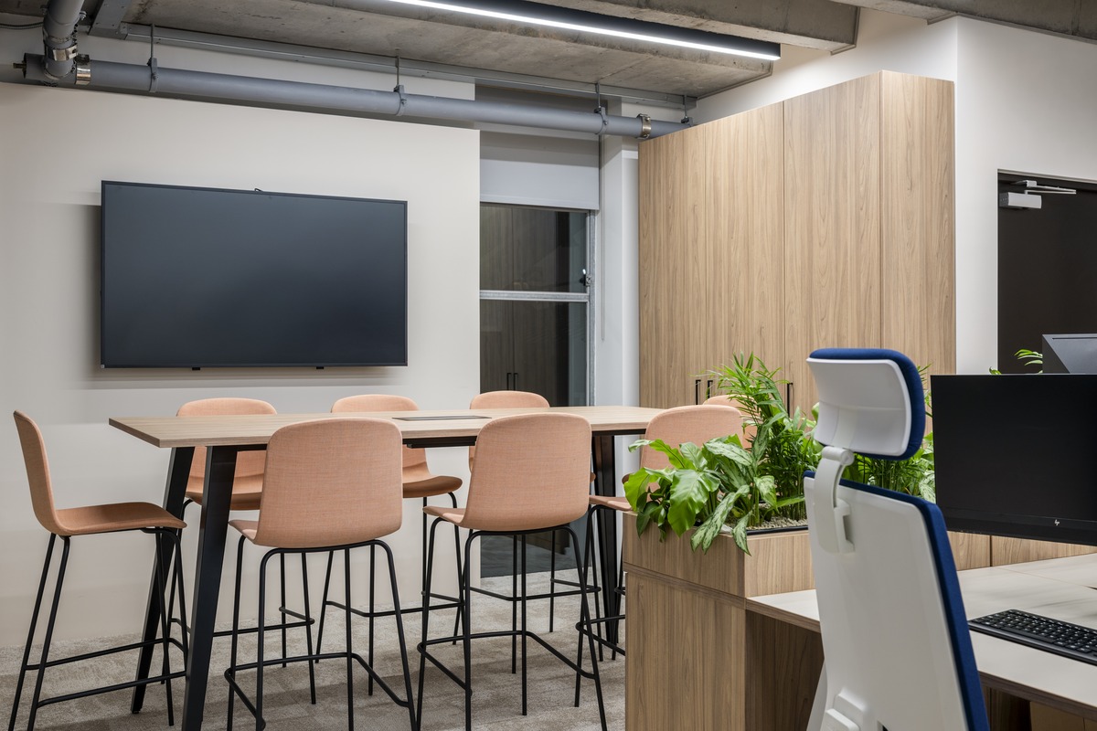 Meeting room with high table, peach stools and planted divider