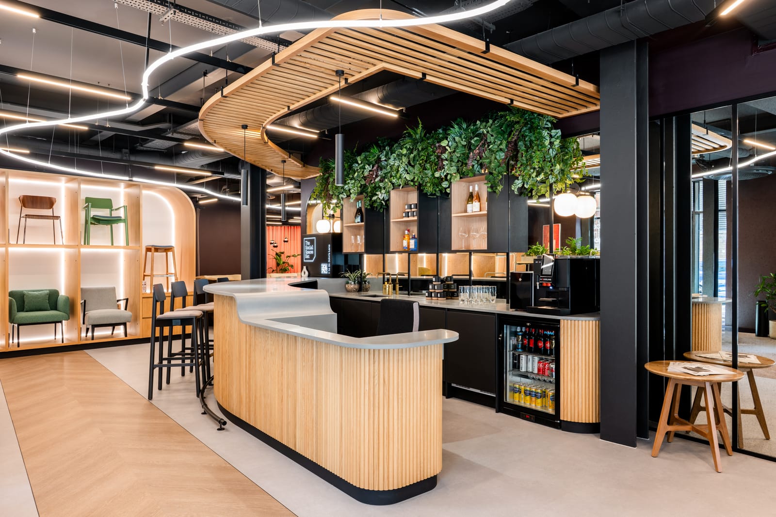 The bespoke bar and reception with a curved slatted timber counter, stone worktop and planted canopy
