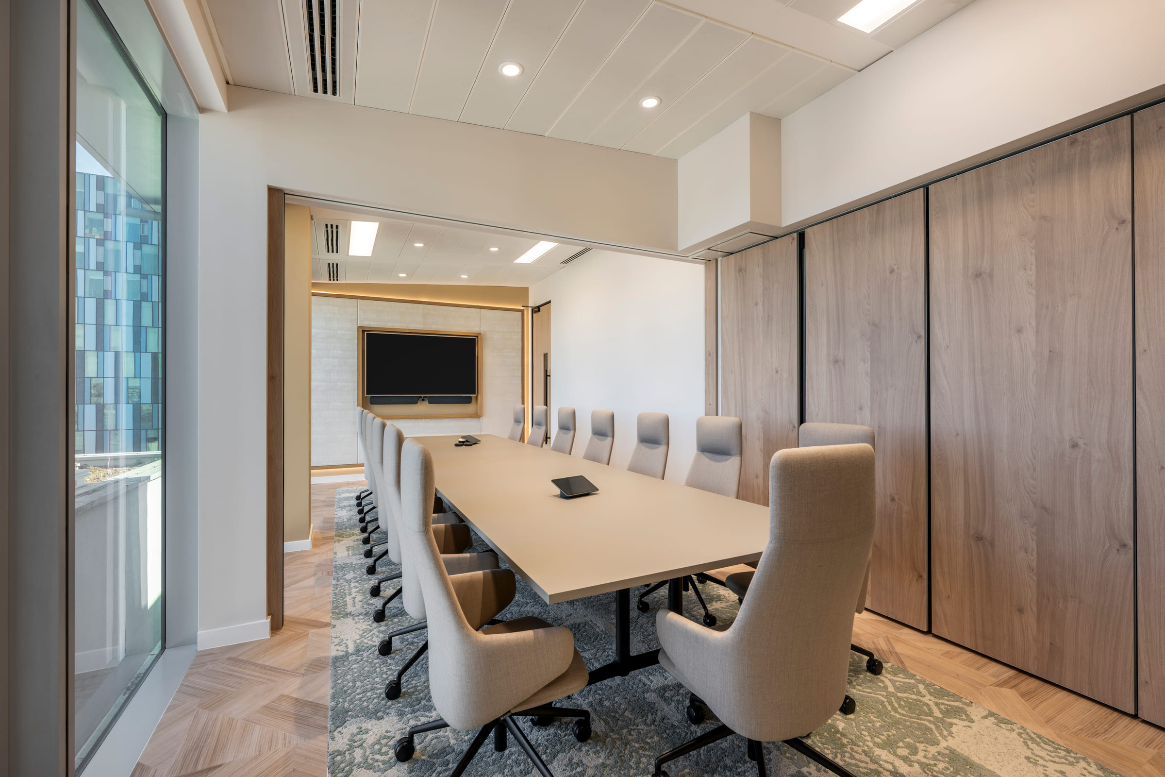 Executive boardroom with cream swivel chairs, long conference table and sliding timber joinery wall