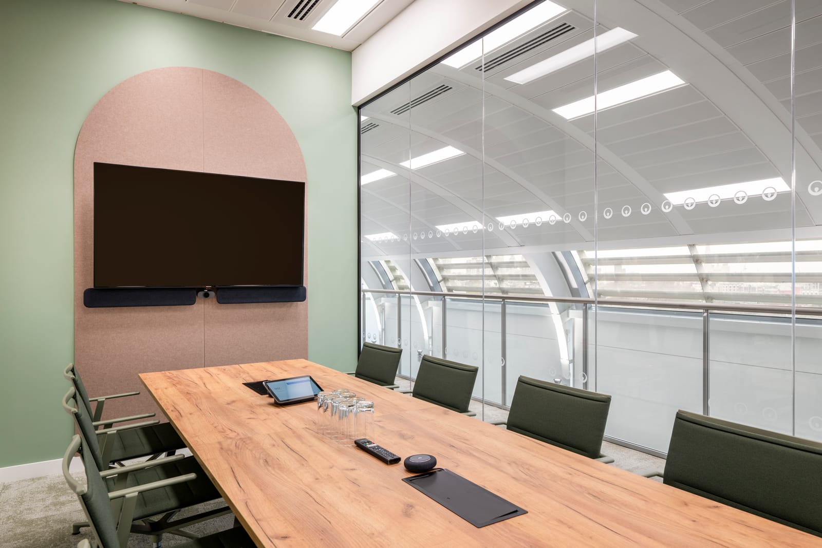 Meeting room with timber table, arch acoustic panel and curved glass windows